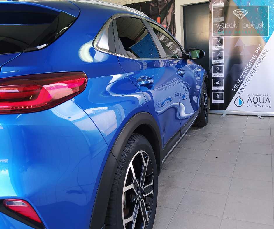 Niebieskie auto po folii PPF i powłoce ceramicznej obok banera Wysoki Połysk